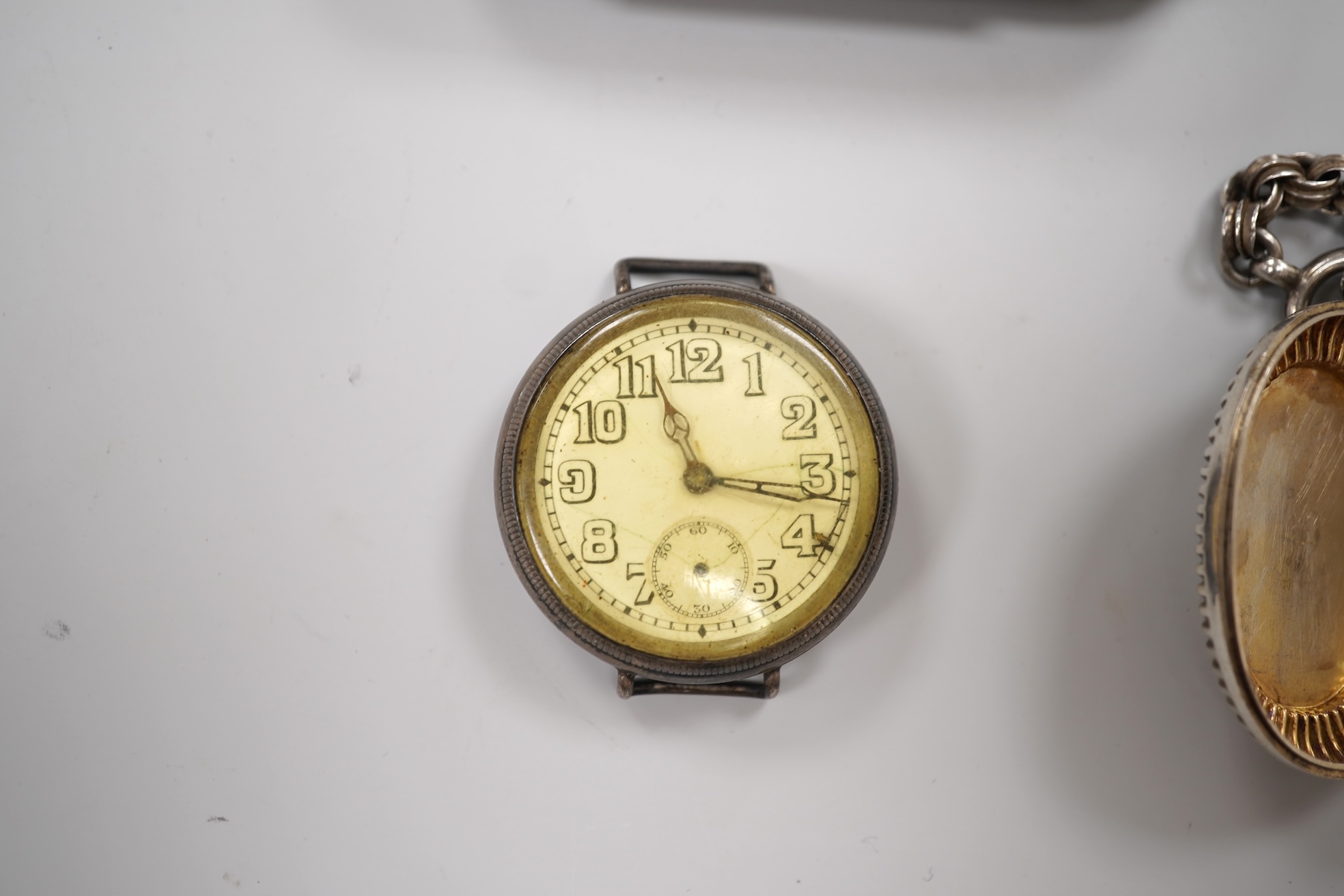 An early 20th century white metal oval locket, 40mm, on a silver chain, a silver plated Dunhill lighter, in Dunhill box, a white metal cased manual wind wrist watch and a tortoiseshell purse.